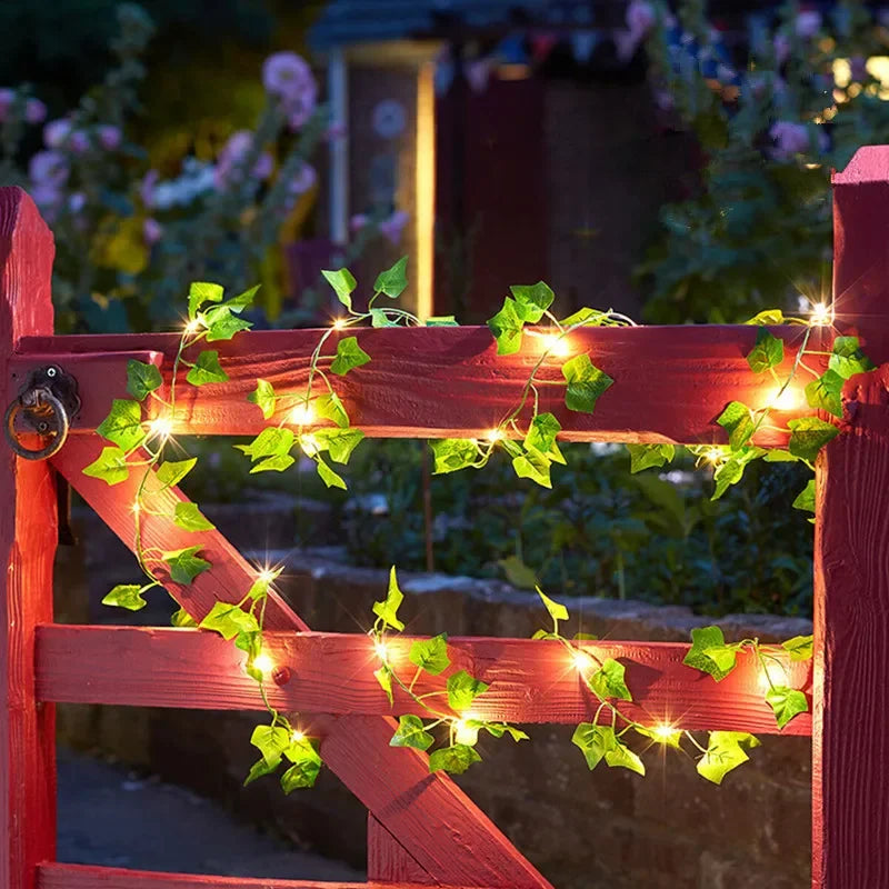Warm ivy string lights draped over a wooden gate, casting a soft golden glow that blends nature and light for a calm evening ambiance — ThuisGemak.