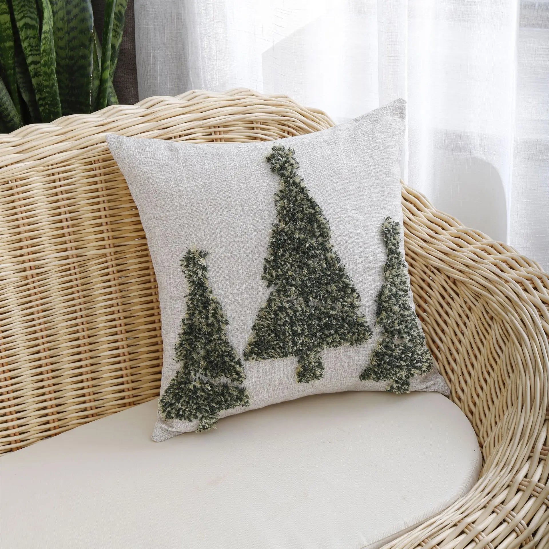 Thuisgemak Festive Tree Cushion with green tufted Christmas tree design on a rattan sofa in a bright UK living room, adding a natural and festive touch.