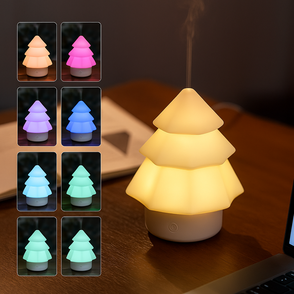 Multi-colour glowing Christmas tree-shaped aroma diffuser emitting gentle mist on a wooden desk beside a laptop, ThuisGemak.