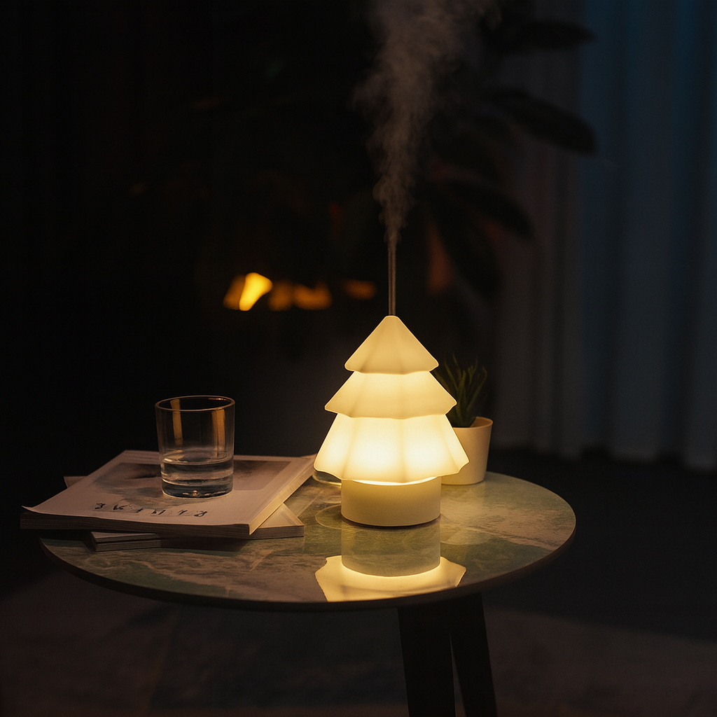 Warm glowing Christmas tree-shaped aroma diffuser releasing a gentle mist on a round table in a softly lit room, ThuisGemak.